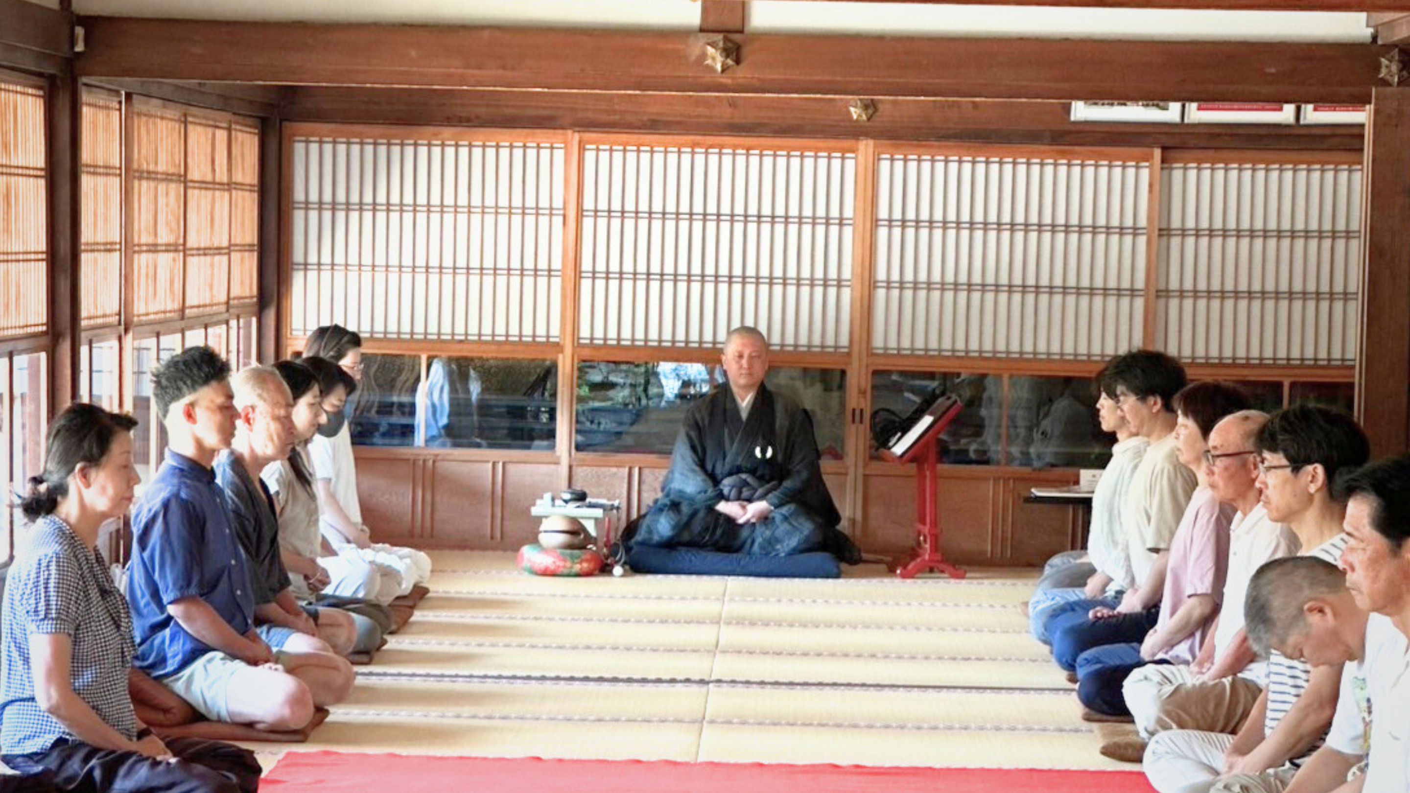 玉藏院本堂での坐禅会 - 住職による法話と参加者が畳の上で正座して坐禅を体験している様子 京都上京区の臨済宗妙心寺派寺院